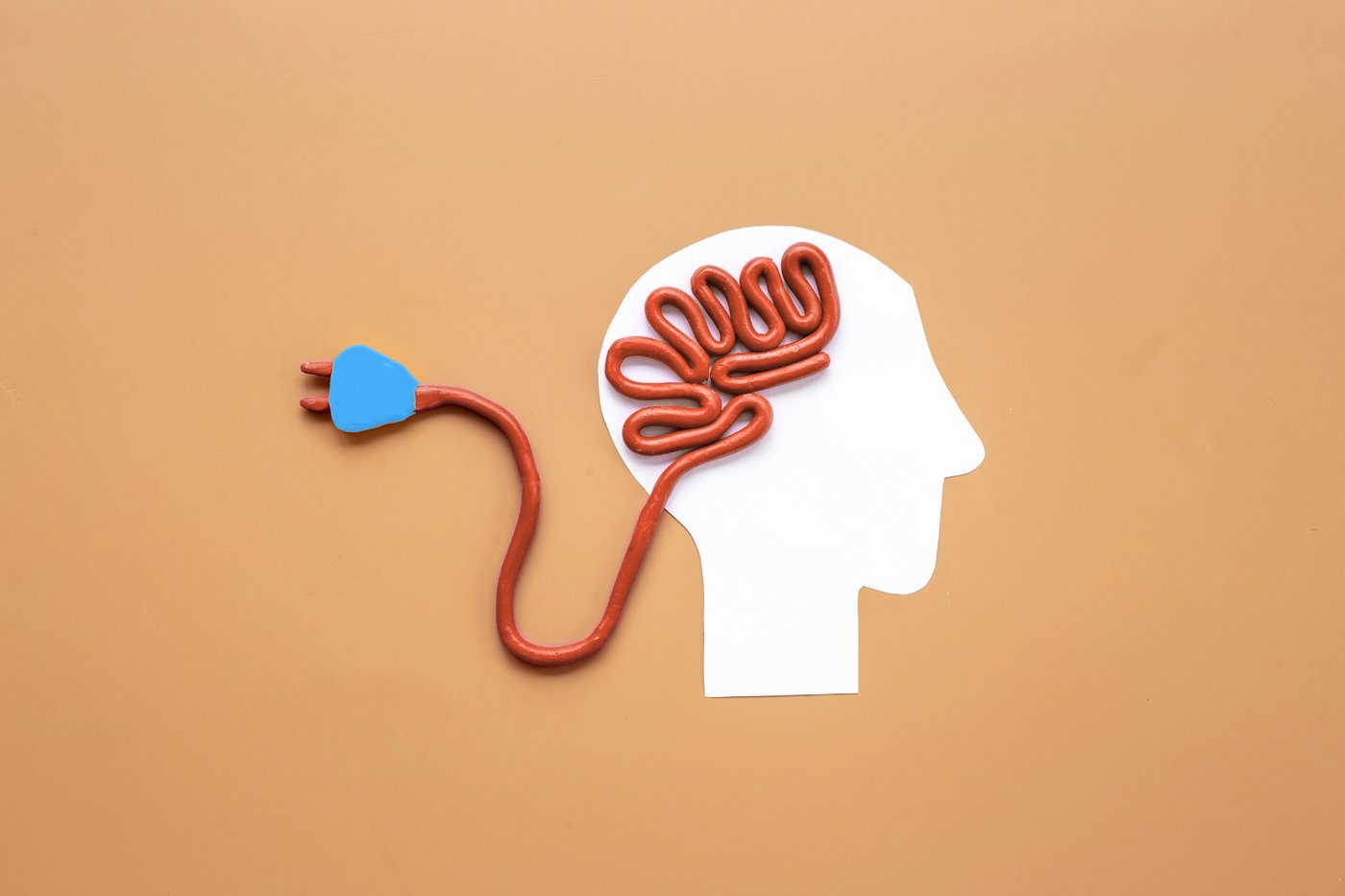 Illustration d’une silhouette de tête avec un cerveau stylisé relié à une prise débranchée