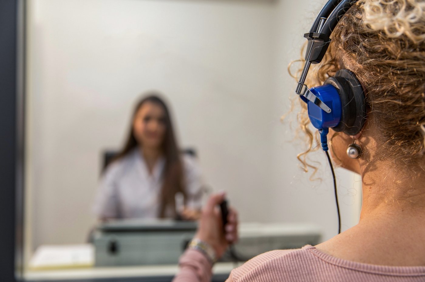 Une patiente portant un casque d’écoute pendant un test d’audition en cabine